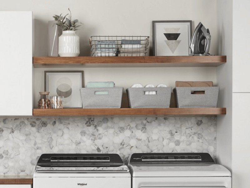 A neatly organized launndry room with a Whirlpool® waaher and dryer.