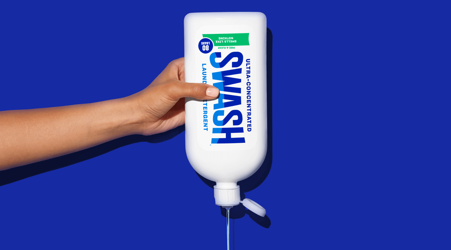 A hand holding a bottle of Swash® Smells Like Nothing