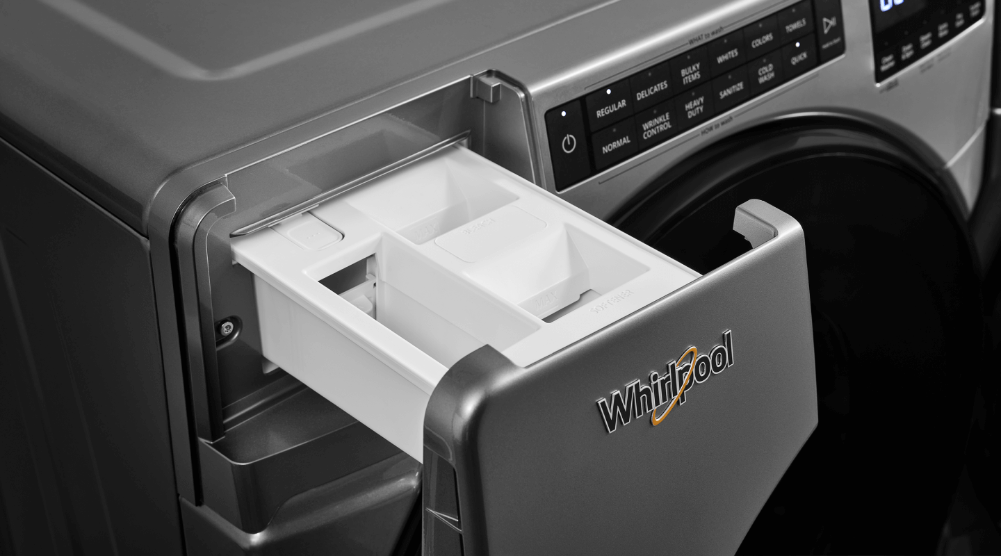 An open laundry detergent dispenser on a Whirlpool front load washing machine.