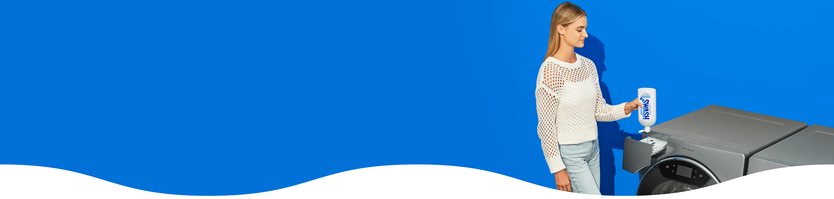 A girl filling a Whirlpool® front load washer with Swash® Laundry Detergent.